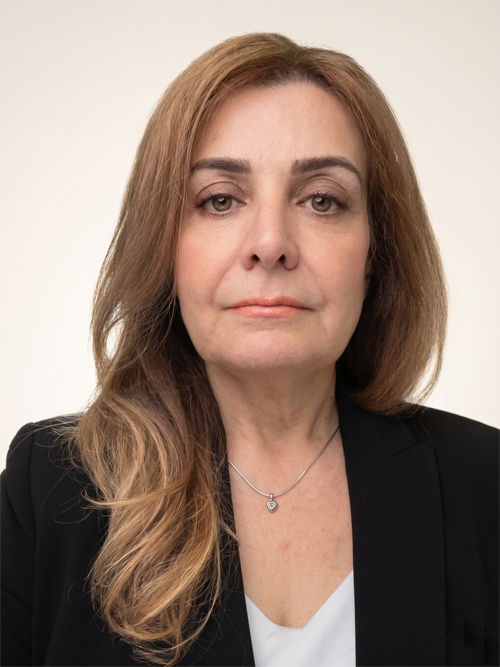Professional head-and-shoulders portrait of a woman with light brown hair, wearing a black blazer and white blouse, neutral expression.